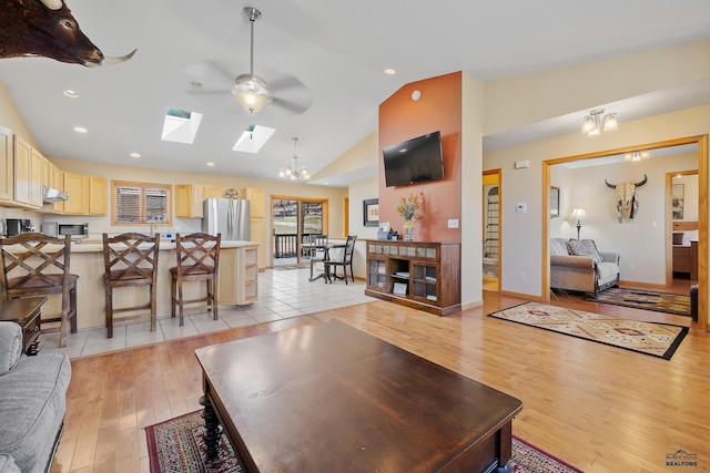 24354 Rushmore Ranch Rd, Keystone, SD 57751 - living room featuring recessed lighting, high vaulted ceiling, ceiling fan with notable chandelier, a skylight, and light wood-style floors