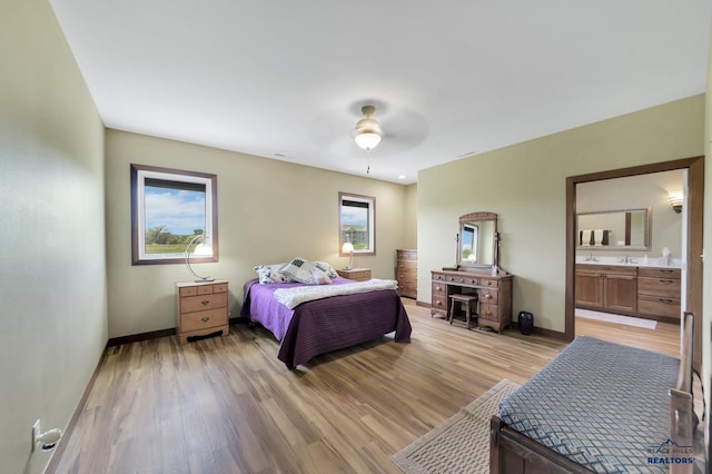 3129 Hazelnut Ln, Rapid City, SD 57703 - bedroom with baseboards, connected bathroom, light wood finished floors, and a ceiling fan
