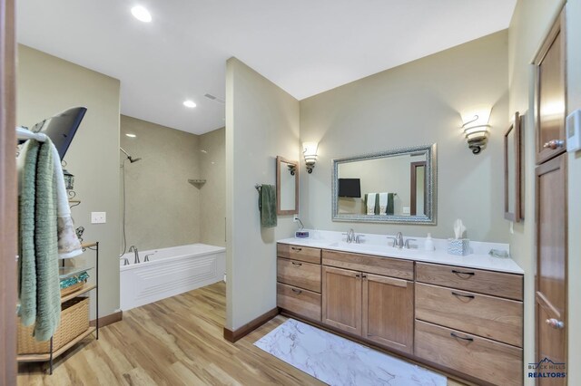 3129 Hazelnut Ln, Rapid City, SD 57703 - bathroom featuring vanity, wood finished floors, a shower, baseboards, and a tub