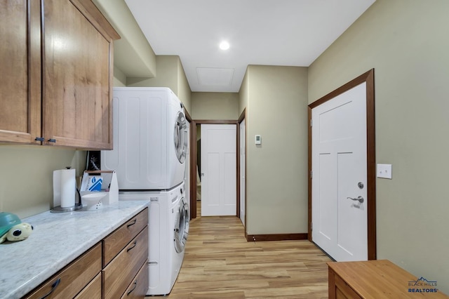 3129 Hazelnut Ln, Rapid City, SD 57703 - laundry room featuring cabinet space, baseboards, stacked washer / dryer, and light wood-style floors