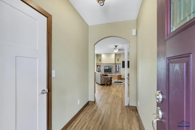 3129 Hazelnut Ln, Rapid City, SD 57703 - foyer featuring arched walkways, baseboards, a ceiling fan, and light wood-style floors