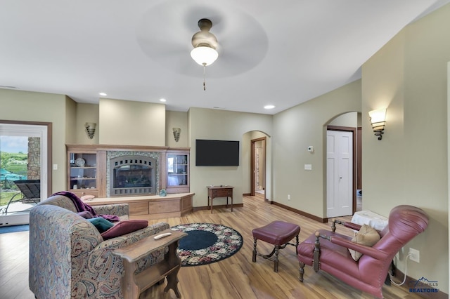 3129 Hazelnut Ln, Rapid City, SD 57703 - living room with baseboards, arched walkways, ceiling fan, and wood finished floors