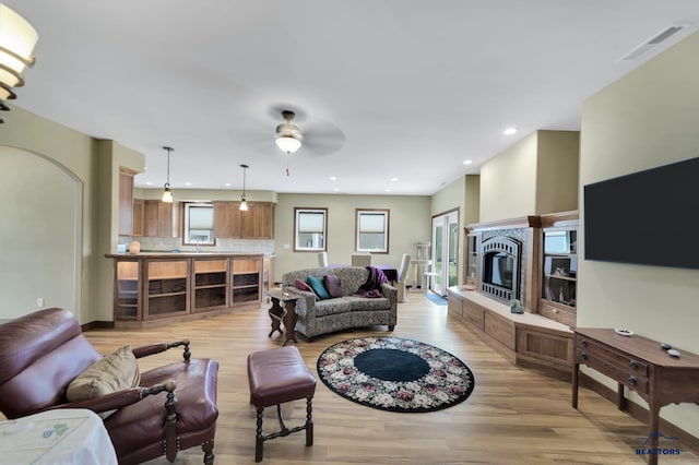 3129 Hazelnut Ln, Rapid City, SD 57703 - living room with ceiling fan, visible vents, a fireplace, recessed lighting, and light wood-style flooring