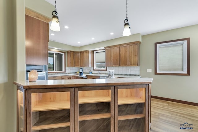 3129 Hazelnut Ln, Rapid City, SD 57703 - kitchen featuring a sink, hanging light fixtures, tasteful backsplash, and brown cabinetry