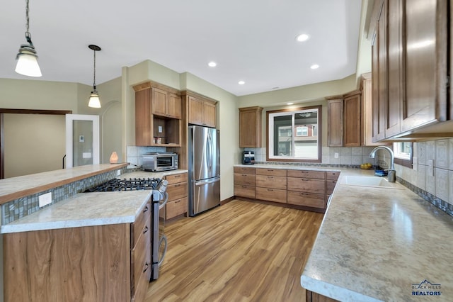3129 Hazelnut Ln, Rapid City, SD 57703 - kitchen with backsplash, appliances with stainless steel finishes, brown cabinets, a sink, and a toaster