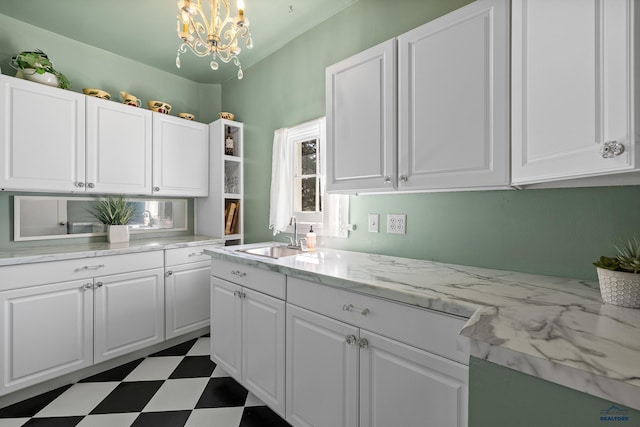kitchen with tile patterned floors, white cabinets, and a sink