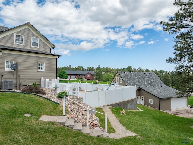 view of yard featuring central AC and fence