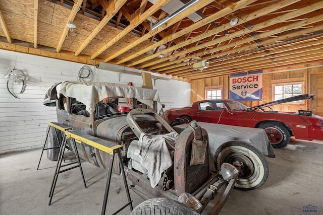 garage with a garage door opener and wooden walls