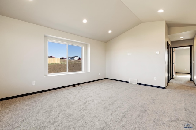 unfurnished room featuring carpet flooring, baseboards, lofted ceiling, and visible vents