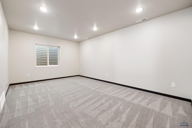carpeted spare room featuring baseboards and recessed lighting