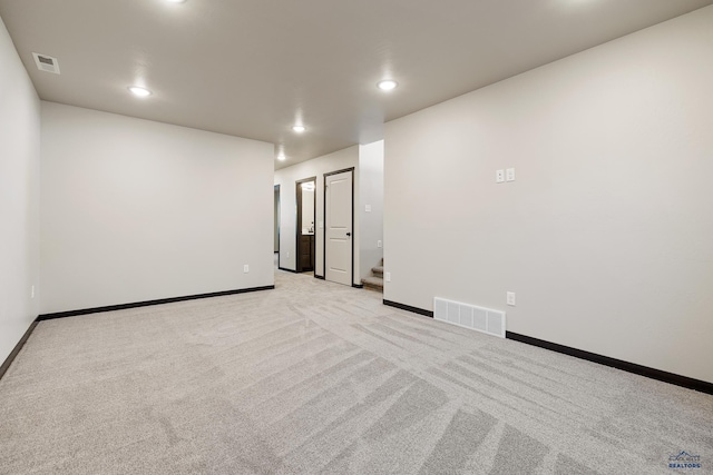 empty room featuring baseboards, visible vents, light colored carpet, and recessed lighting