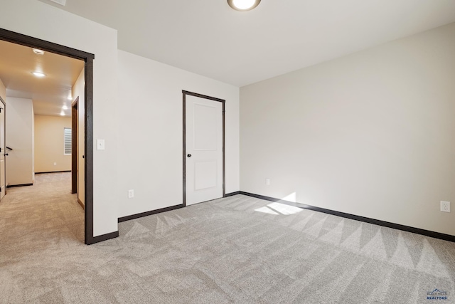 unfurnished bedroom featuring baseboards and light colored carpet