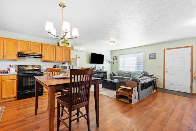524 Mall Dr, Rapid City, SD 57701 - dining space with light wood-style flooring, a notable chandelier, an AC wall unit, and a textured ceiling
