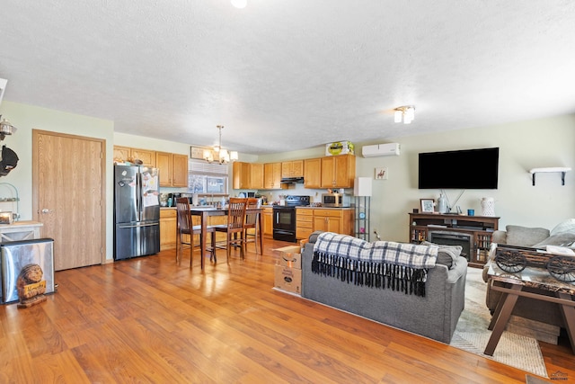 524 Mall Dr, Rapid City, SD 57701 - living room with a fireplace, a textured ceiling, light wood-style floors, and a notable chandelier