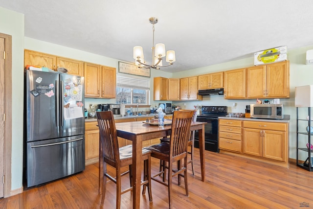 524 Mall Dr, Rapid City, SD 57701 - kitchen with wood finished floors, under cabinet range hood, appliances with stainless steel finishes, and a chandelier