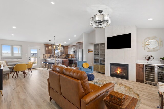 4403 Targhee Dr, Rapid City, SD 57702 - living room featuring lofted ceiling, recessed lighting, light wood-style floors, beverage cooler, and a fireplace