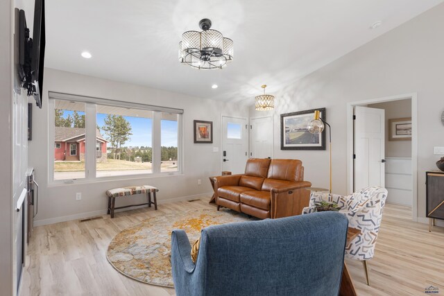 4403 Targhee Dr, Rapid City, SD 57702 - living room with baseboards, a notable chandelier, light wood-type flooring, and vaulted ceiling