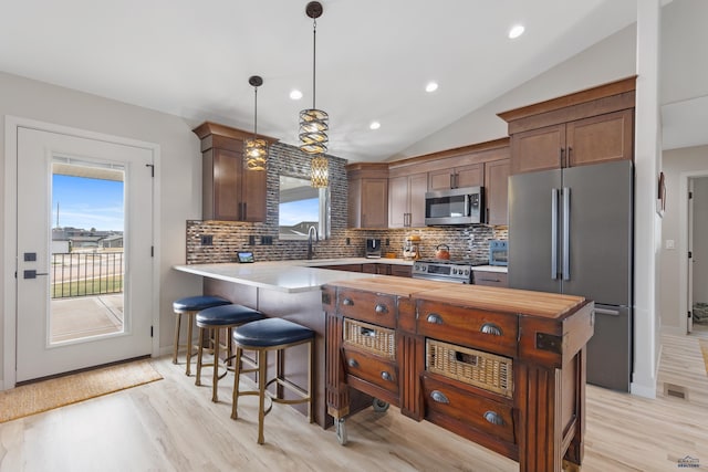 4403 Targhee Dr, Rapid City, SD 57702 - kitchen featuring a kitchen bar, plenty of natural light, appliances with stainless steel finishes, and lofted ceiling