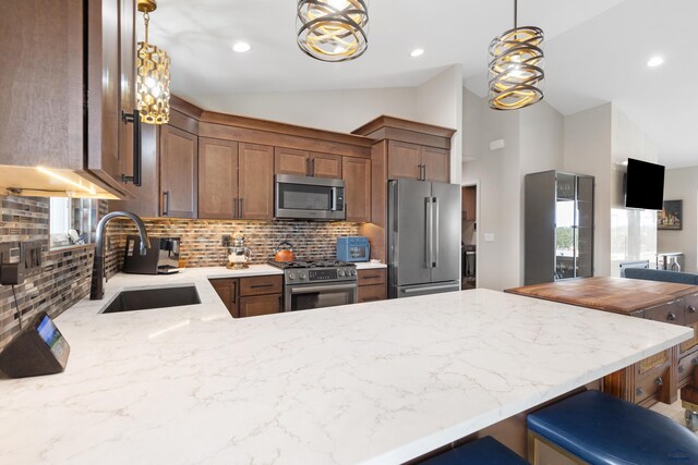 4403 Targhee Dr, Rapid City, SD 57702 - kitchen featuring a sink, light stone countertops, appliances with stainless steel finishes, a peninsula, and lofted ceiling