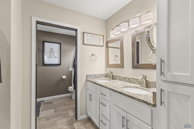 2750 Tumble Weed Trl, Spearfish, SD 57783 - bathroom featuring a sink, toilet, double vanity, and baseboards
