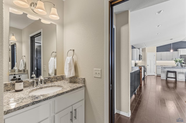2750 Tumble Weed Trl, Spearfish, SD 57783 - bathroom with a textured wall, vanity, wood finished floors, and lofted ceiling