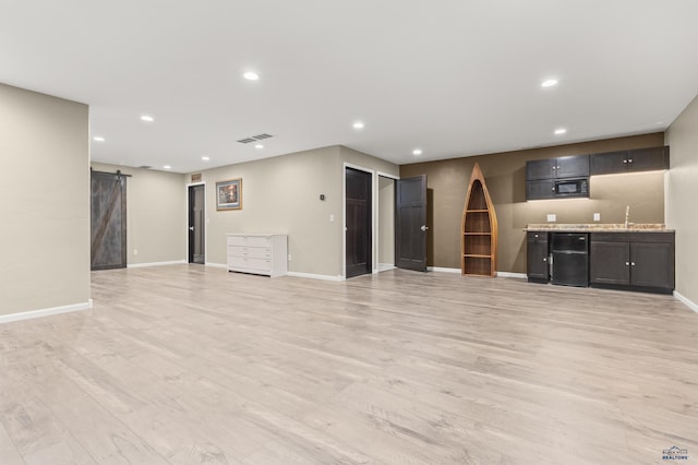 2750 Tumble Weed Trl, Spearfish, SD 57783 - unfurnished living room with visible vents, a barn door, indoor wet bar, light wood-style floors, and recessed lighting