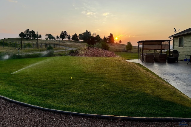 2750 Tumble Weed Trl, Spearfish, SD 57783 - yard at dusk featuring concrete driveway, a patio, a detached carport, and fence