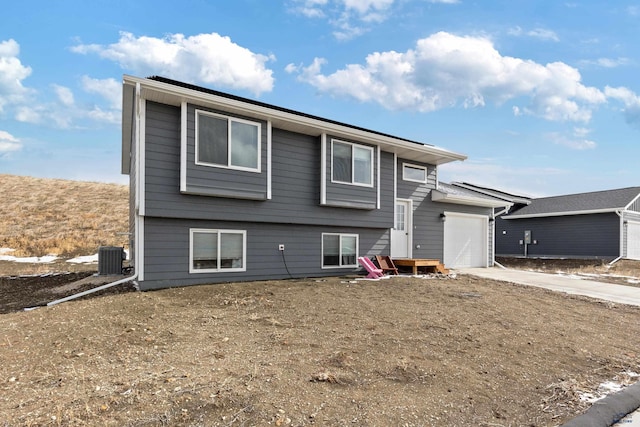 view of front of house featuring a garage, driveway, and central AC