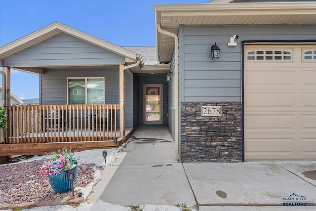2678 Meadows Dr, Sturgis, SD 57785 - doorway to property with a porch, stone siding, and an attached garage