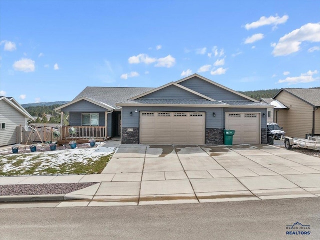 2678 Meadows Dr, Sturgis, SD 57785 - view of front of home with an attached garage, a shingled roof, stone siding, and concrete driveway