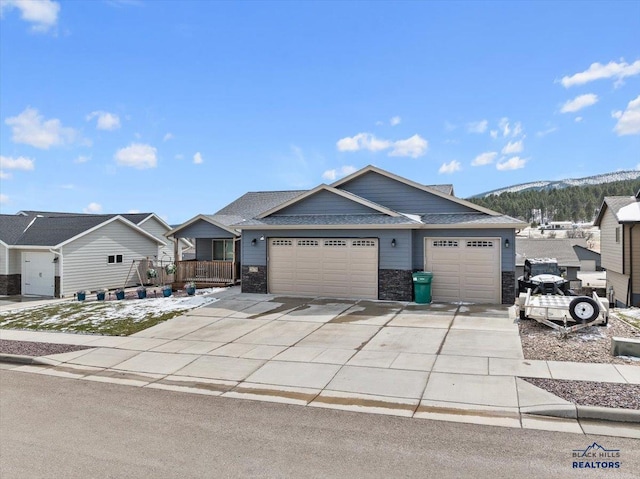 2678 Meadows Dr, Sturgis, SD 57785 - view of front facade featuring driveway, a shingled roof, stone siding, and a garage