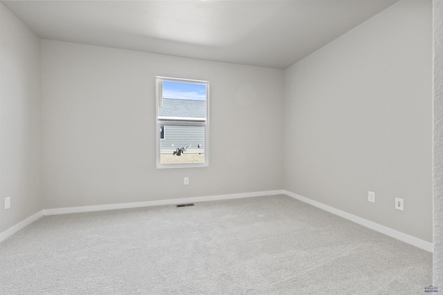 carpeted empty room featuring visible vents and baseboards