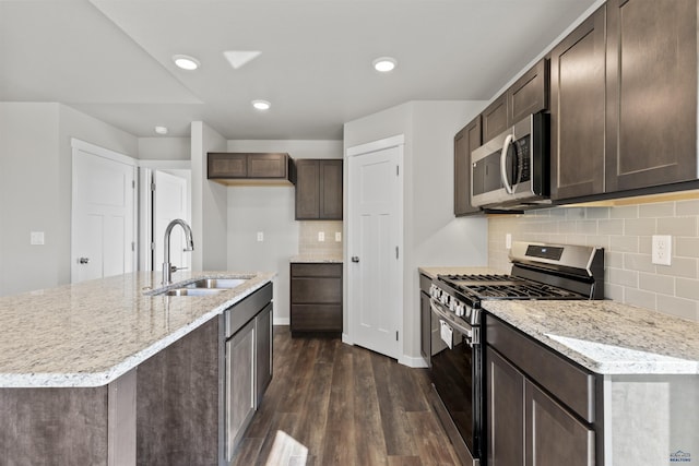 kitchen featuring dark brown cabinetry, dark wood-type flooring, recessed lighting, appliances with stainless steel finishes, and a sink