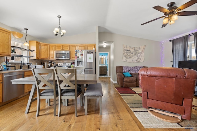 dining area with baseboards, light wood-type flooring, vaulted ceiling, and ceiling fan with notable chandelier
