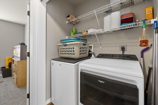 washroom featuring washer and dryer, carpet flooring, and laundry area