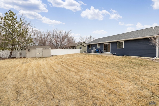 view of yard with an outbuilding, a fenced backyard, a patio, and a storage unit