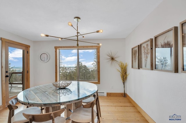dining room with a wealth of natural light, light wood-type flooring, and a notable chandelier
