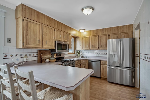 3112 Flint Dr, Rapid City, SD 57702 - kitchen featuring a kitchen bar, a peninsula, appliances with stainless steel finishes, and light countertops