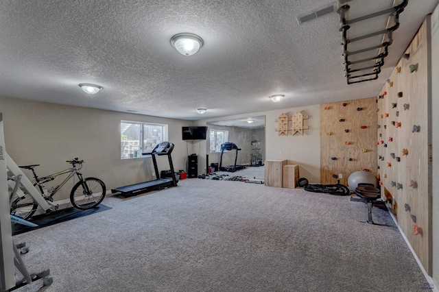 workout room with visible vents, a textured ceiling, and carpet floors