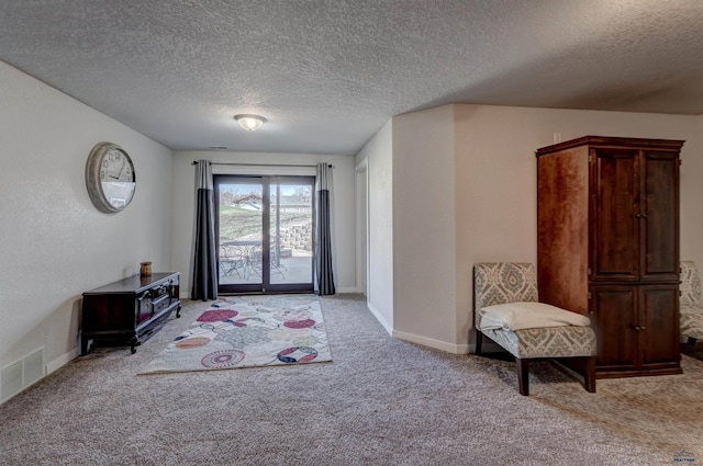 entrance foyer featuring visible vents, baseboards, light carpet, and a textured ceiling