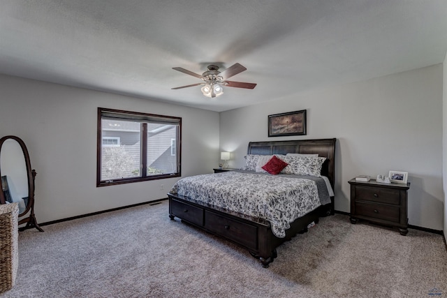 carpeted bedroom featuring baseboards and a ceiling fan