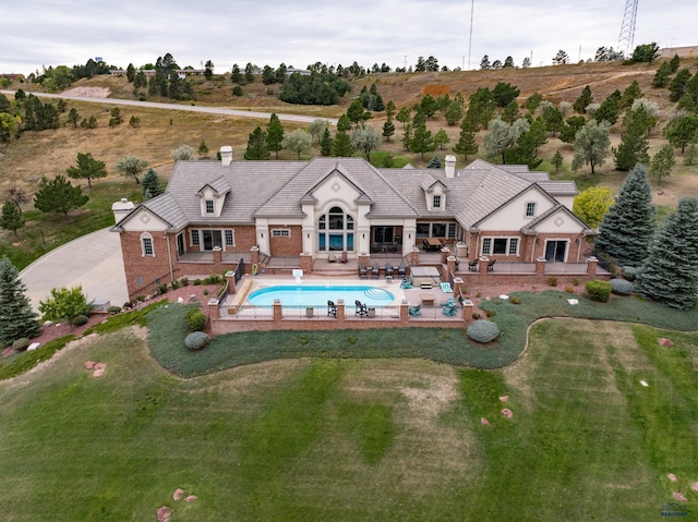 1334 Alta Vista Dr, Rapid City, SD 57701 - rear view of property with a patio, a chimney, an outdoor pool, brick siding, and a yard