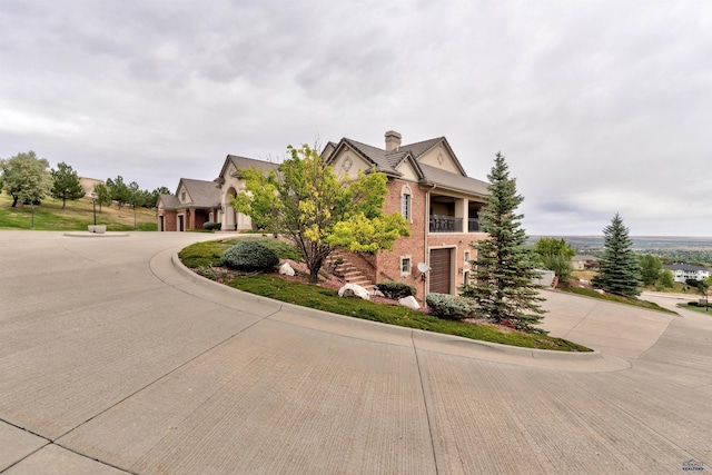 1334 Alta Vista Dr, Rapid City, SD 57701 - view of front of property featuring a chimney, curved driveway, a garage, and a balcony