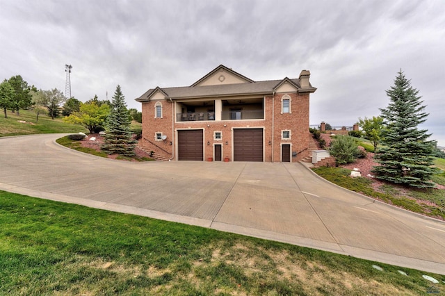 1334 Alta Vista Dr, Rapid City, SD 57701 - view of front of home with concrete driveway, a balcony, a chimney, an attached garage, and brick siding