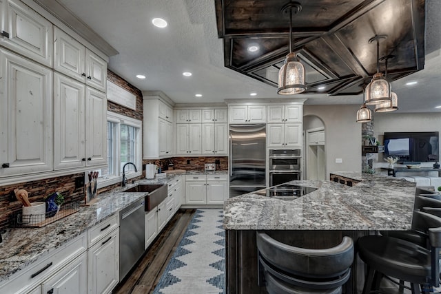 1334 Alta Vista Dr, Rapid City, SD 57701 - kitchen featuring a sink, white cabinetry, stainless steel appliances, dark wood-type flooring, and light stone counters