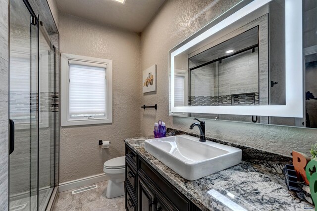 1334 Alta Vista Dr, Rapid City, SD 57701 - full bathroom featuring a textured wall, toilet, baseboards, and a stall shower