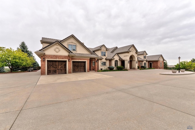 1334 Alta Vista Dr, Rapid City, SD 57701 - view of front of house with brick siding, a garage, driveway, and stucco siding