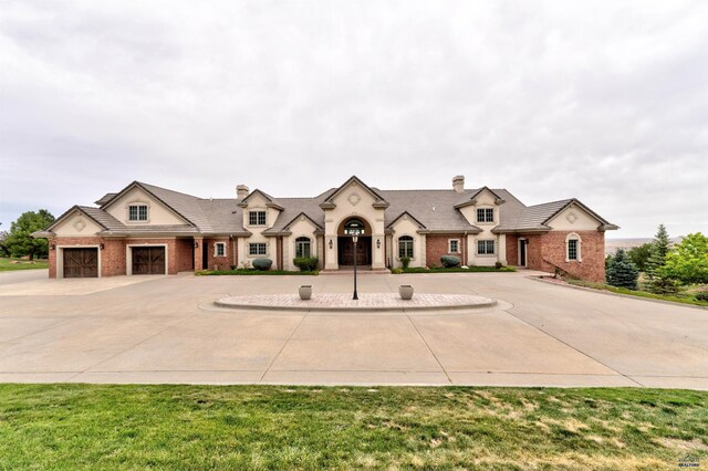 1334 Alta Vista Dr, Rapid City, SD 57701 - french country home featuring brick siding, curved driveway, and a chimney