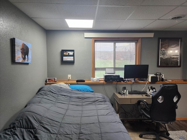 322 Summit, Belle Fourche, SD 57717 - bedroom featuring baseboards, wood finished floors, a drop ceiling, and a textured wall