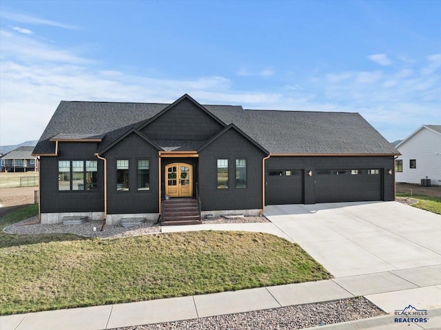 modern inspired farmhouse featuring roof with shingles, a front lawn, a garage, and concrete driveway